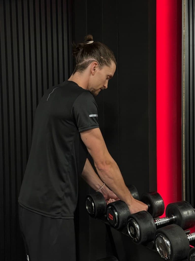 Martin Pavlovský u stojanu s jednoručkami v BlackField gym